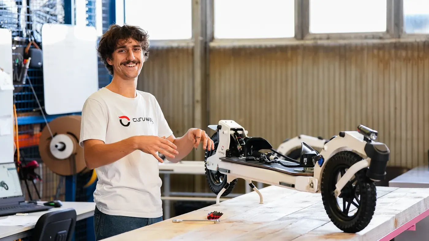 A designer examines and compares the rendering of the 3D printed object with its digital version displayed on screen, in order to assess the differences and the fidelity of the final model.