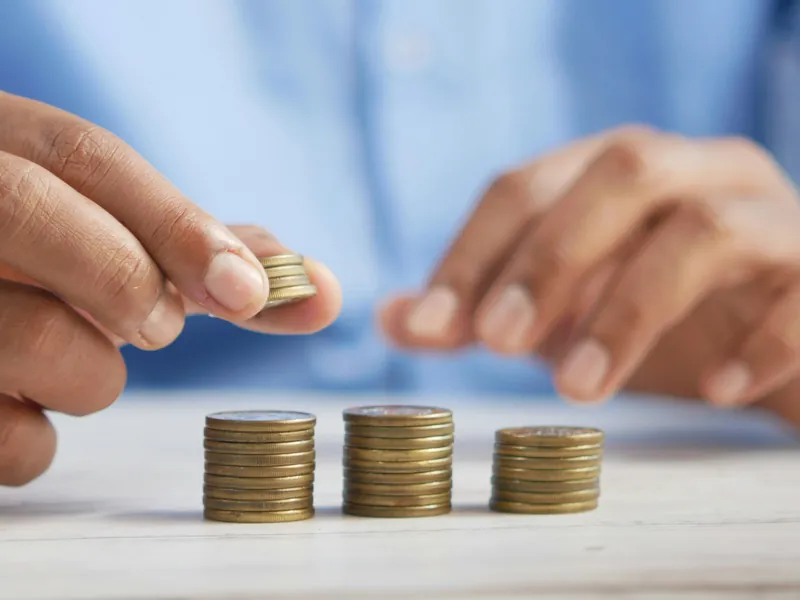 Mains empilant des pièces de monnaie sur une table